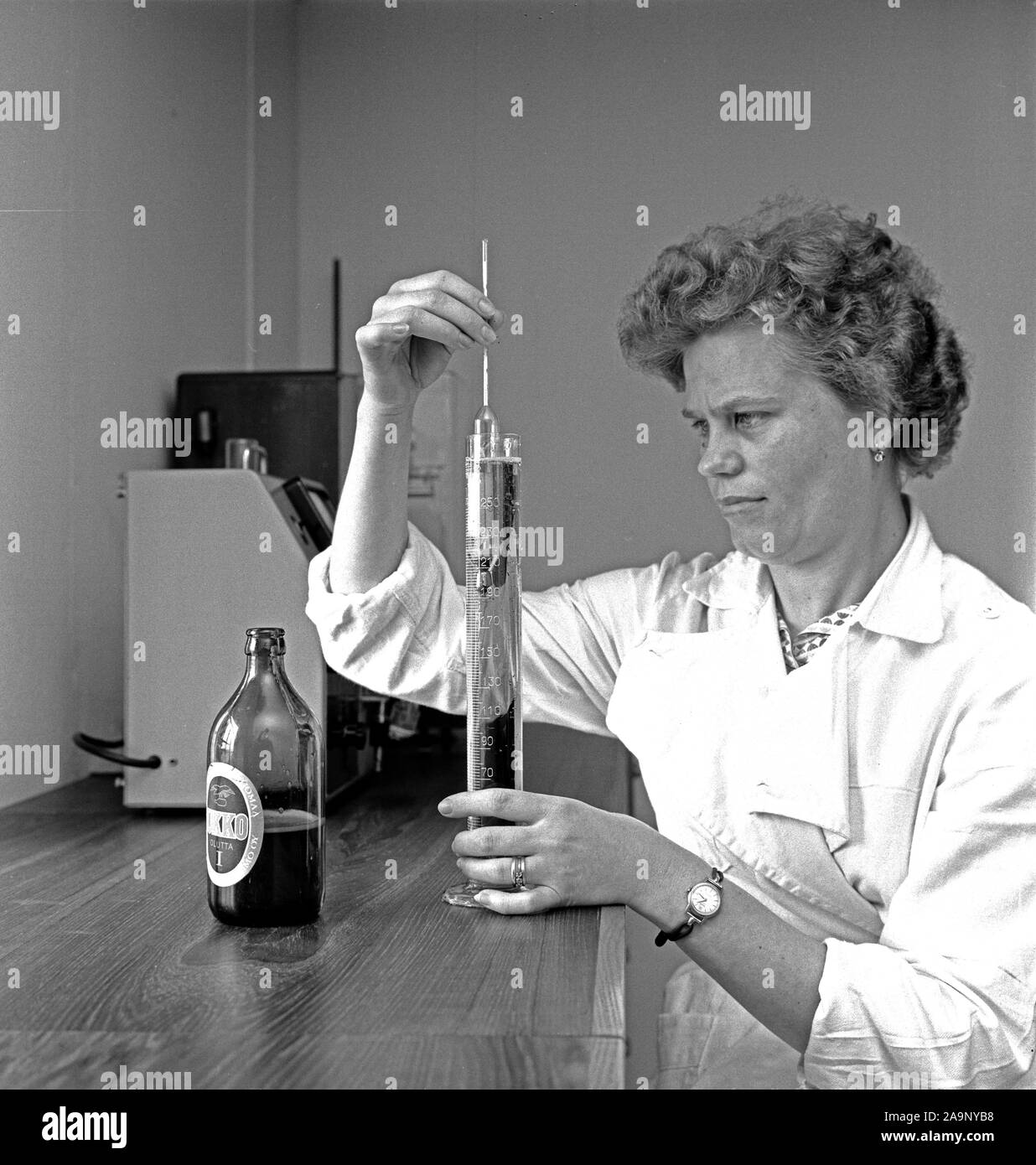 Finland History - Kotka Steam Brewery inspector inspects the quality of the bottled beer.  ca. 1960 Stock Photo