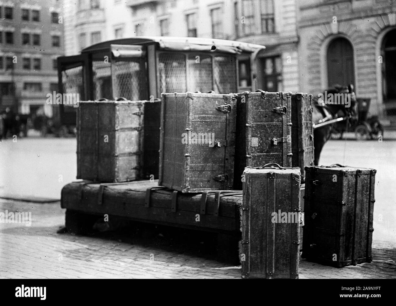 Packing trunks sitting on the side of a city street ca. 1909-1914 Stock Photo