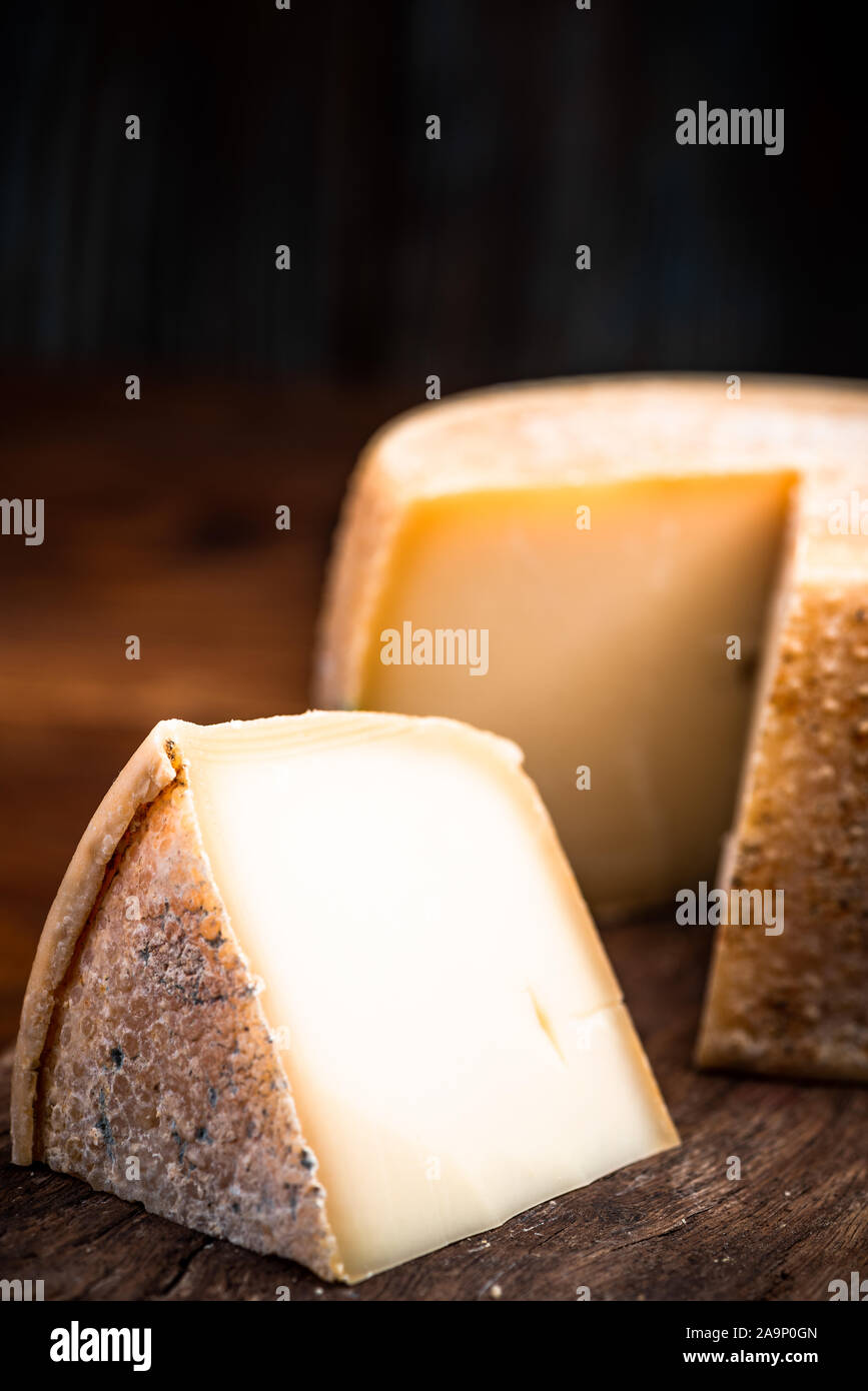 Aged Hard Cheese Wheel and Triangle Cut. Diary Cellar and Local Produce. Stock Photo
