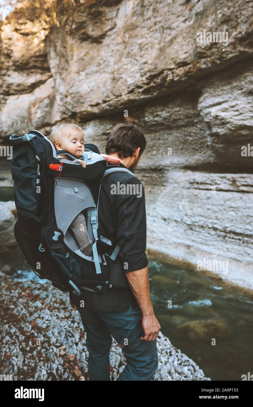 Father hiking with baby in backpack carrier travel adventure family