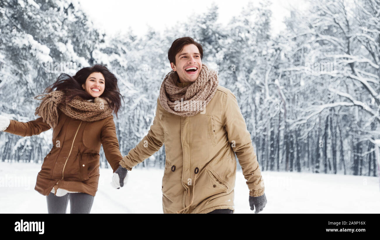 Couple Walking Holding Hands In Snowy Forest, Panorama Stock Photo - Alamy
