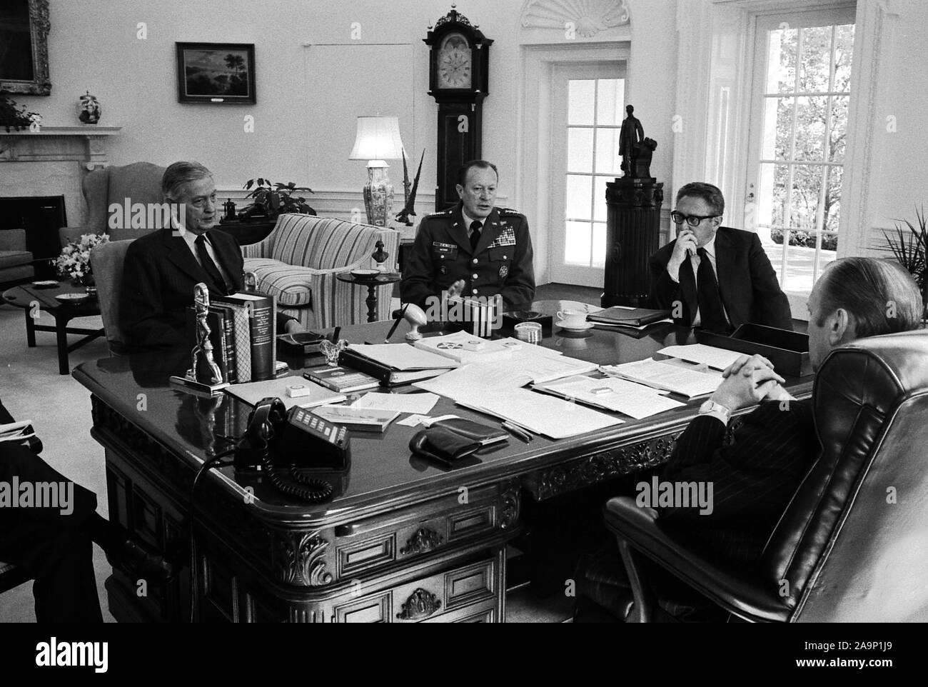 This photograph was taken in the Oval Office of the White House. Pictured with President Ford are Brent Scowcroft, Deputy Assistant to the President for National Security Affairs; Graham Martin, United States Ambassador to the Republic of Vietnam; Army Chief of Staff General Frederick Weyand; and Secretary of State Henry A. Kissinger.  Gerald Ford has his back to the camera. Brent Scowcroft is partially obscured. Stock Photo