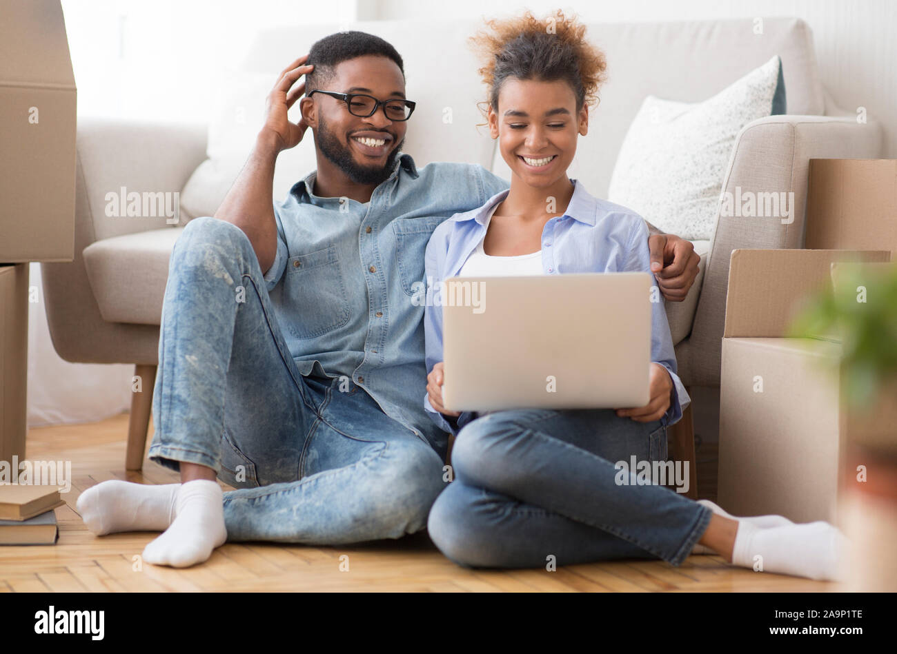 Black Couple Using Laptop Sitting On Floor In New Apartment Stock Photo ...