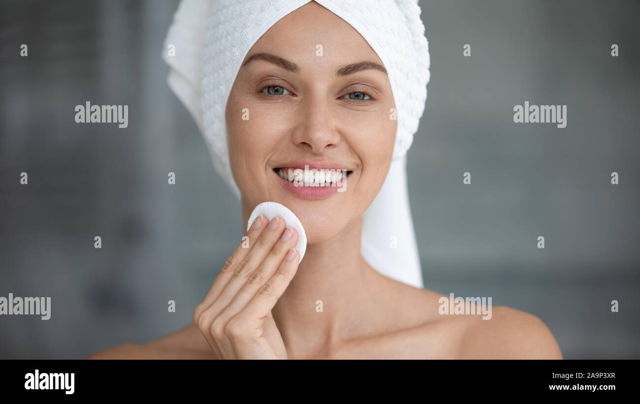 Smiling beautiful woman hold cotton pad cleansing face skin Stock Photo