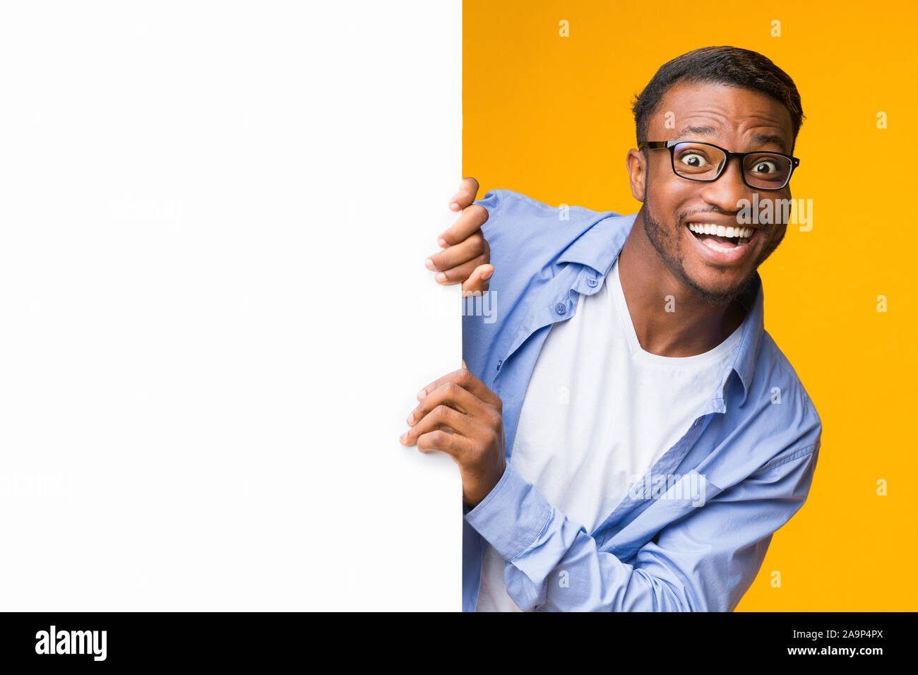 funny-black-guy-looking-out-of-white-board-studio-mockup-stock-photo