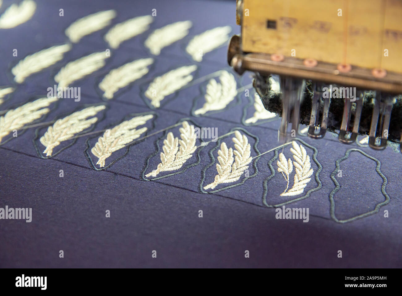 Close up with embroidery machine working on a blue matrix. Work in progress Stock Photo