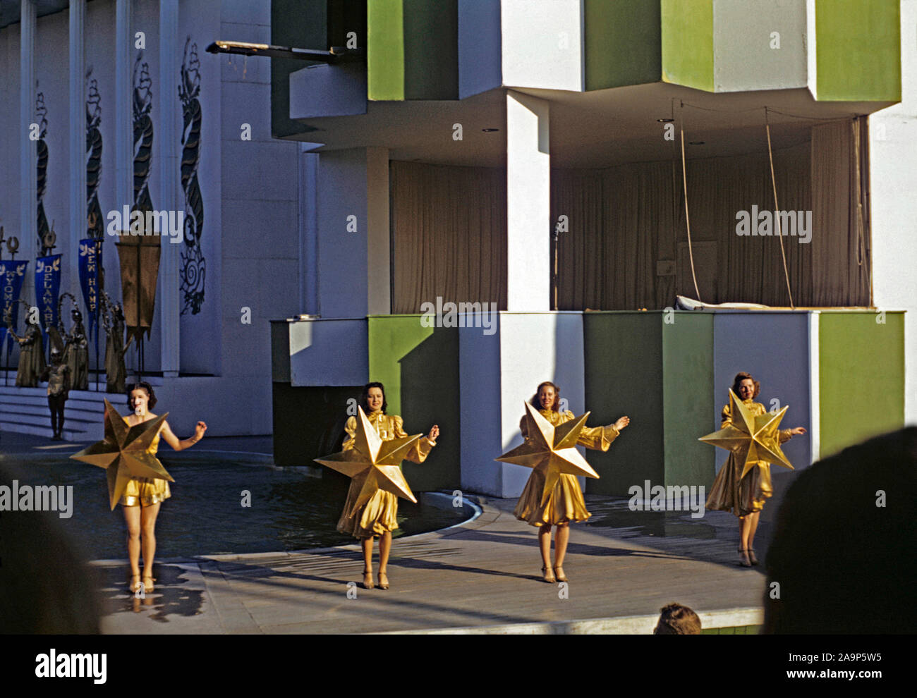 Female models holding up gold stars at the Billy Rose Aquacade, a water