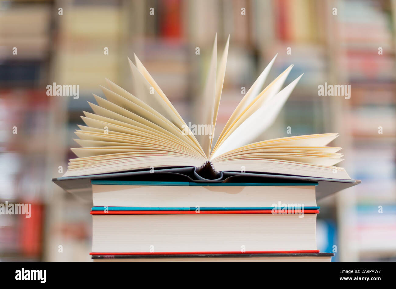 open novel on a stack of books Stock Photo