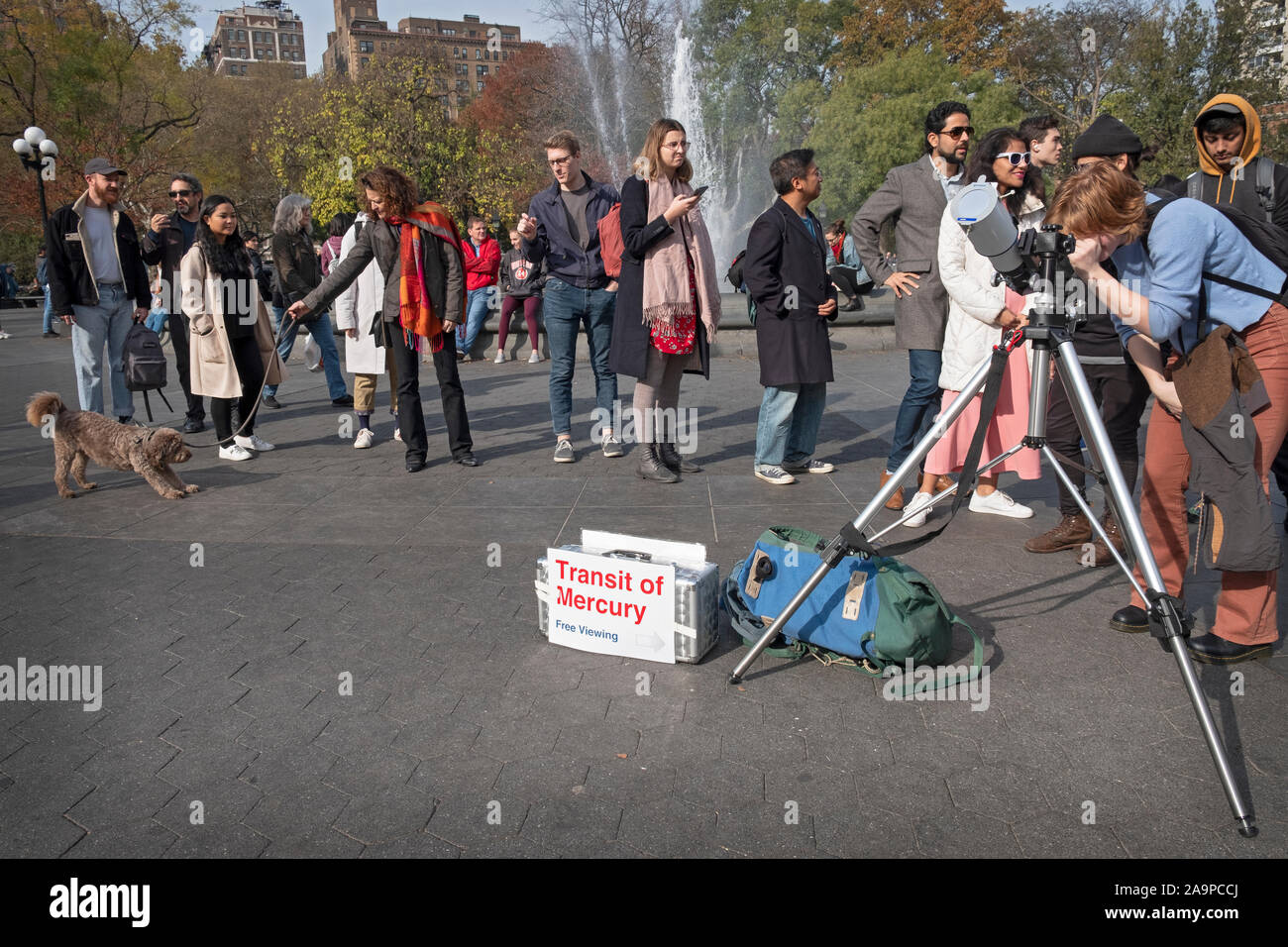 Curious people of all ages line up to look though a telescope & see the rare passing of Mercury between the earth & the sun. Stock Photo