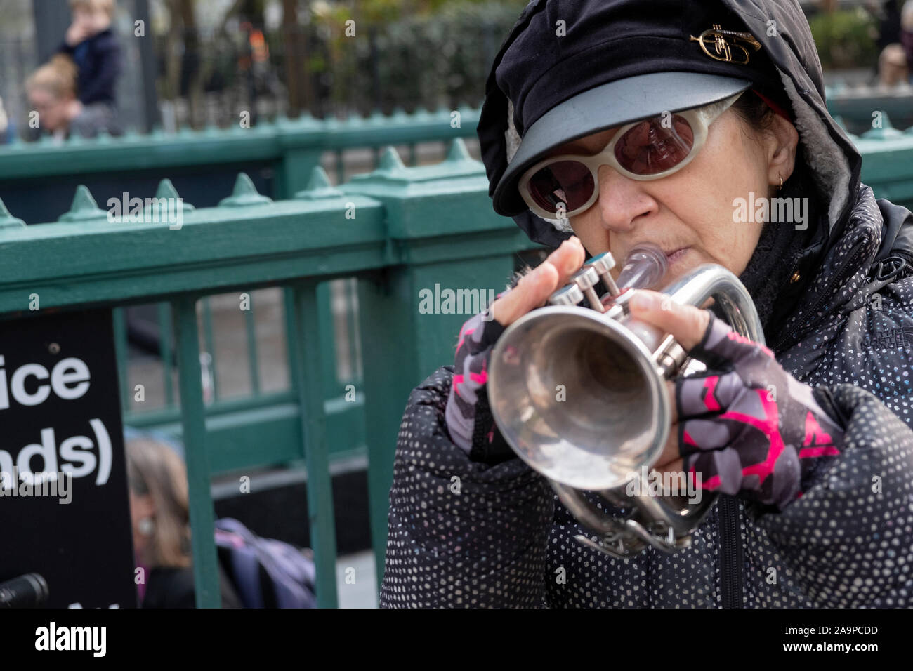 GINETTA'S VENDETTA. A middle aged pocket trumpet player performing outdoors on a cold Autumn day. In Union Square Park, Manhattan, New York City. Stock Photo