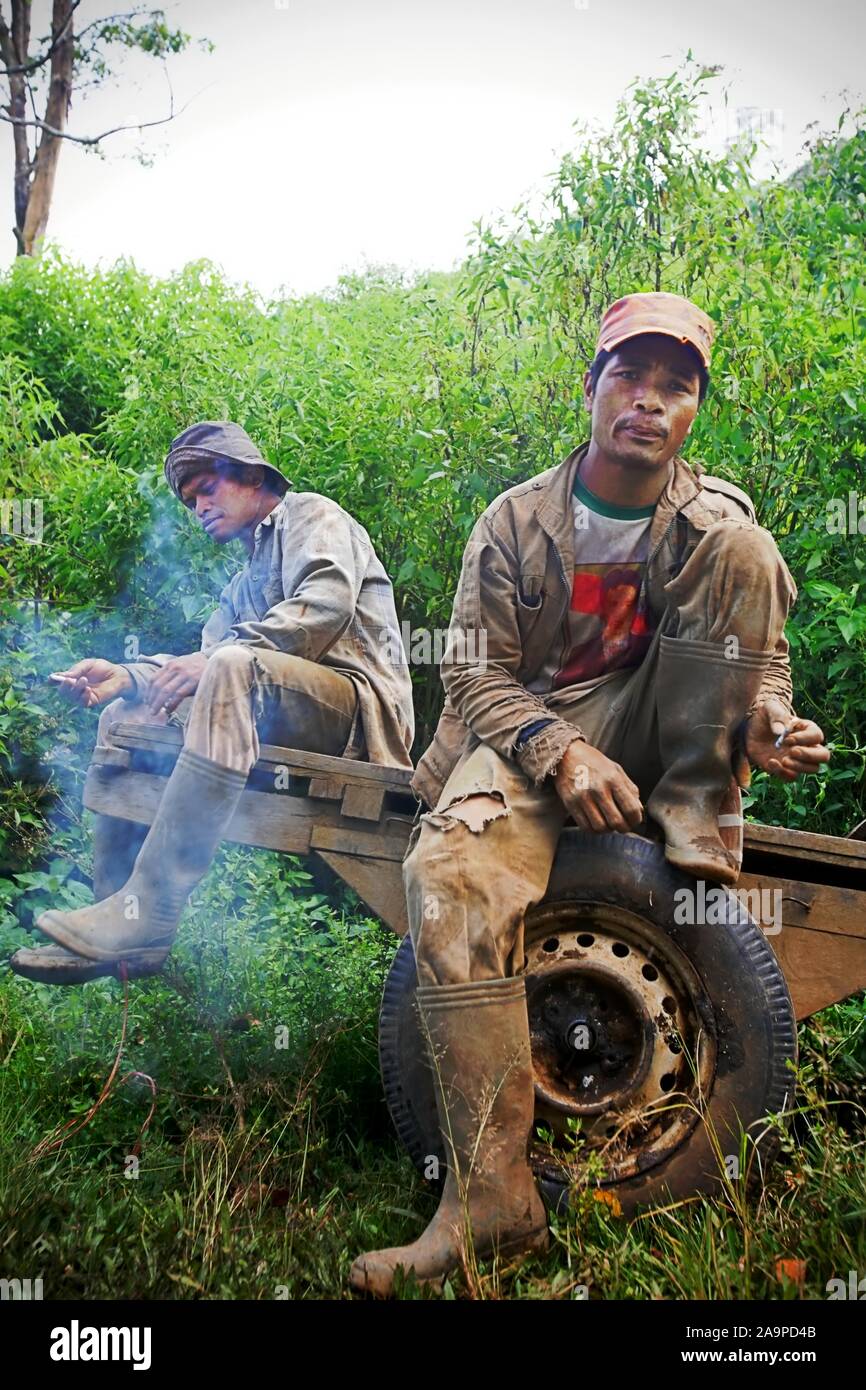 Portrait of agricultural workers smoking as they are sitting on a wooden cart in Gunung Tujuh, Kerinci, Jambi, Indonesia. Stock Photo