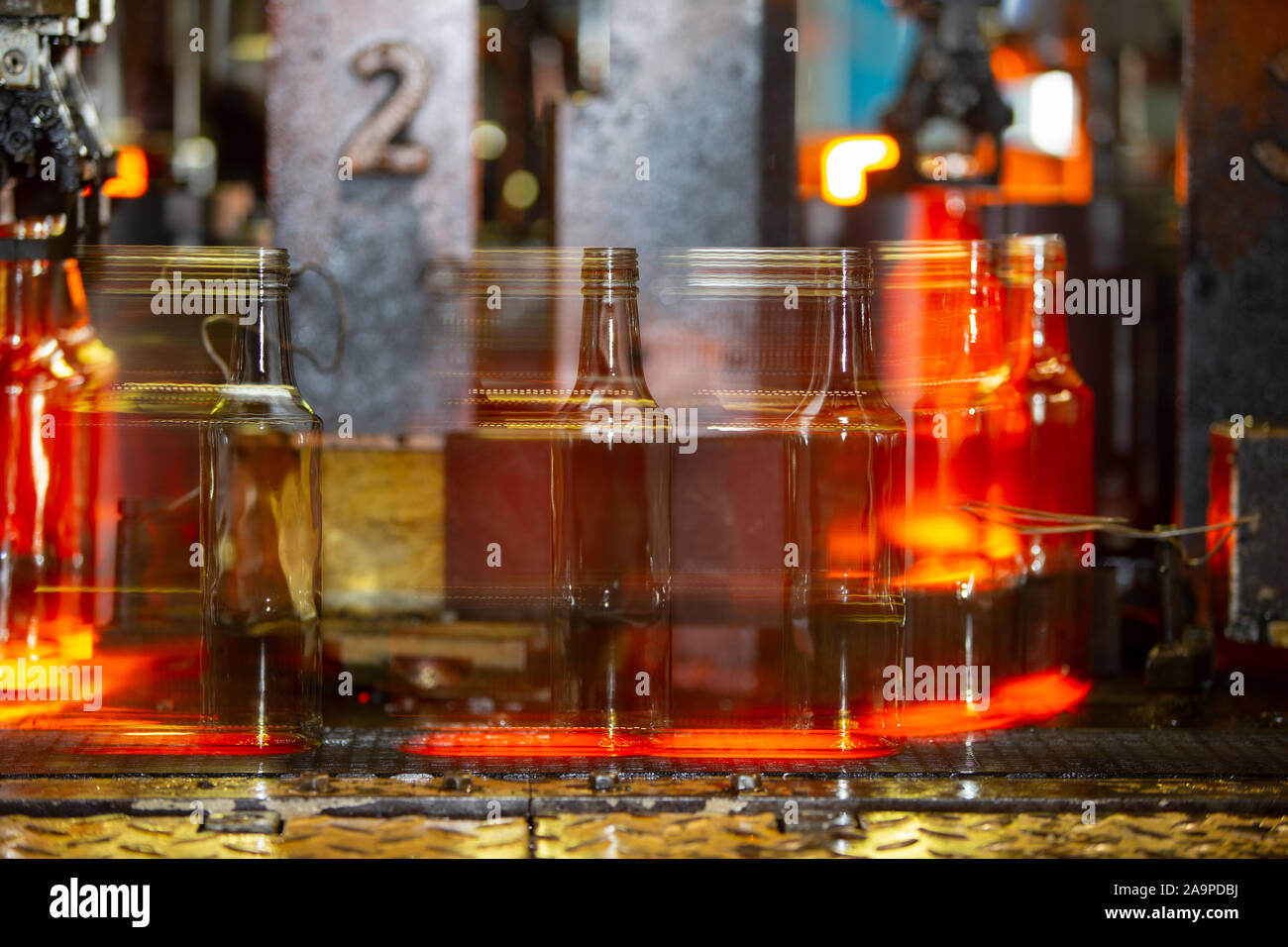 Glassworks. Glass industry. Hot bottles on an industrial conveyor shot long exposure Stock Photo