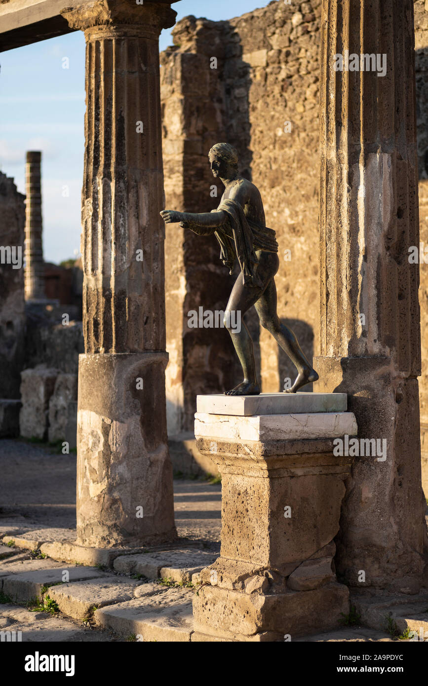Pompei. Italy. Archaeological site of Pompeii. Tempio di Apollo / Temple of Apollo, bronze replica of the statue of Apollo Saettante (archer) shooting Stock Photo