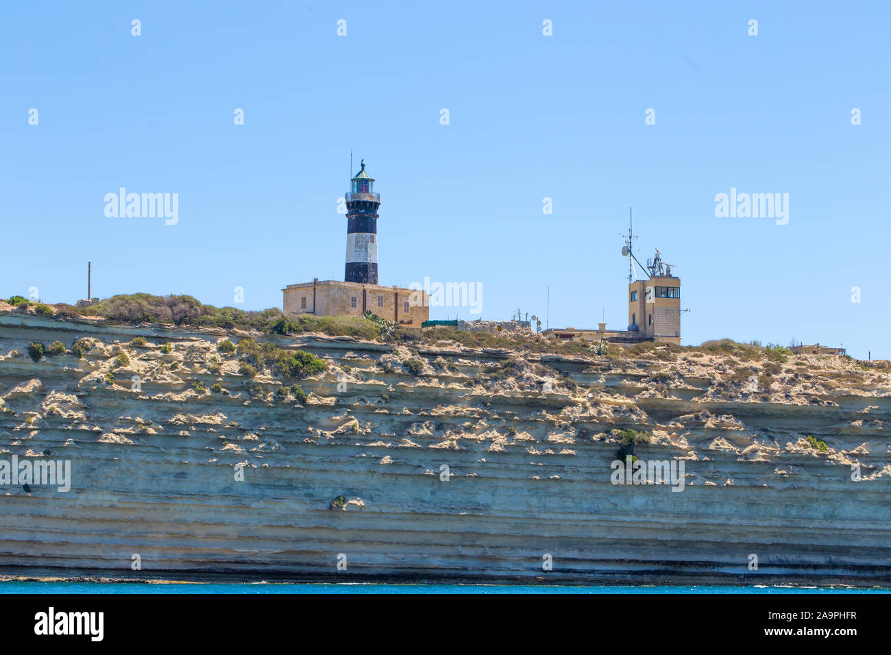 Old maltese bunkers with lighthouse at Malta Stock Photo - Alamy