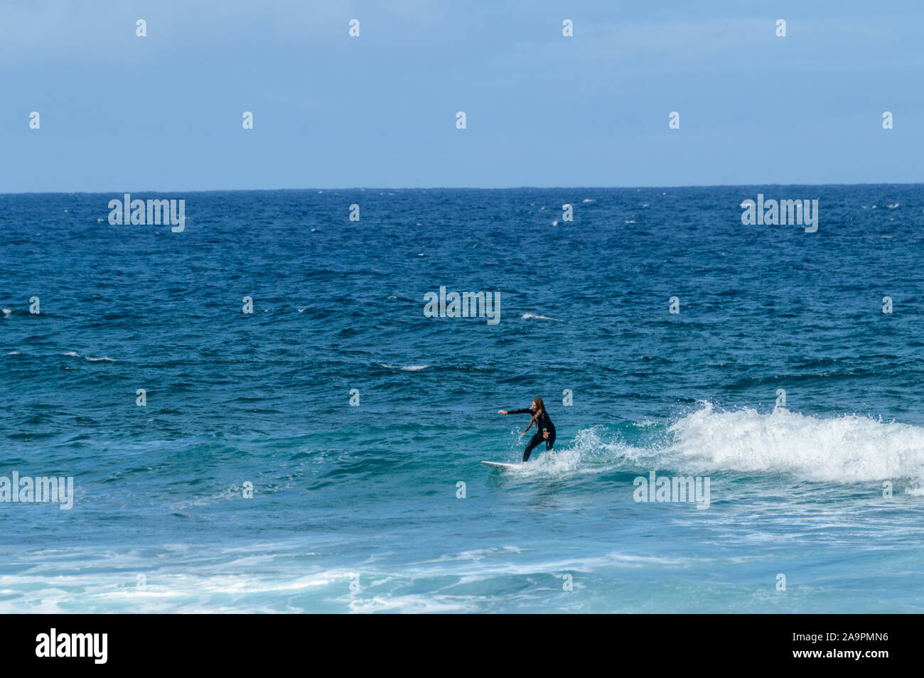 Caucasian Surfer With Dreadlocks Blonde Hair Catching Waves On Las Americas Beach. April 11, 2019. Santa Cruz De Tenerife Spain Africa. Travel Tourism Stock Photo