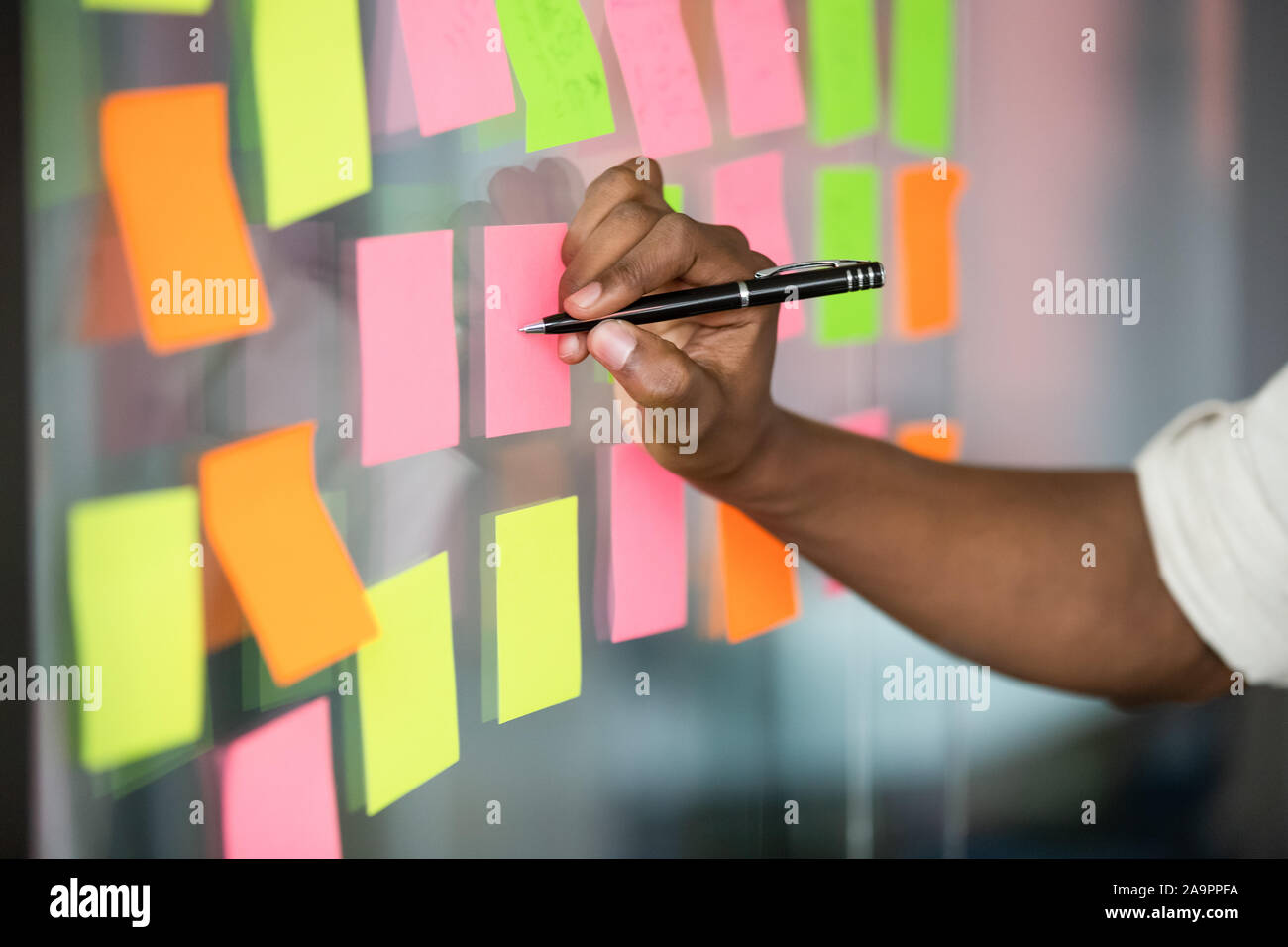 Close up african american manager writing notes on kanban board. Stock Photo