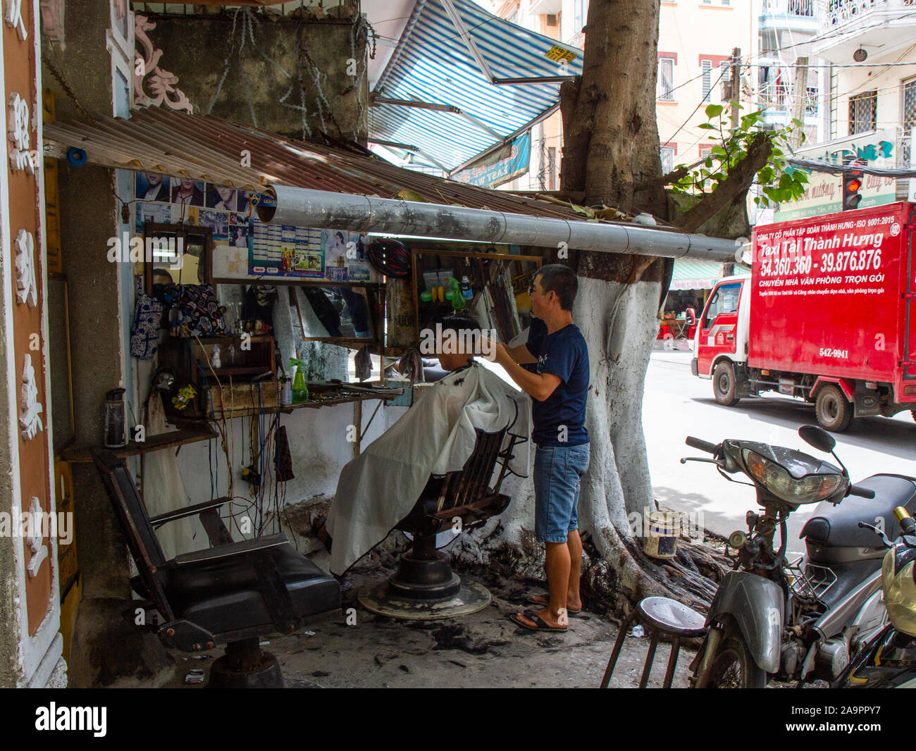 Outdoor barber, street scene Saigon, Ho Chi Minh City Vietnam Stock Photo