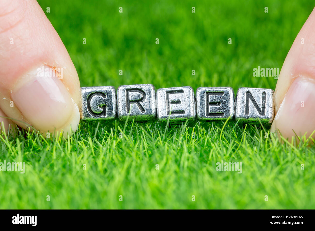 Слово green. Зеленое написано на металле. Цифра 67 выложена на траве и ткани. Слово семью написано на зеленом. Как пишется Грин.