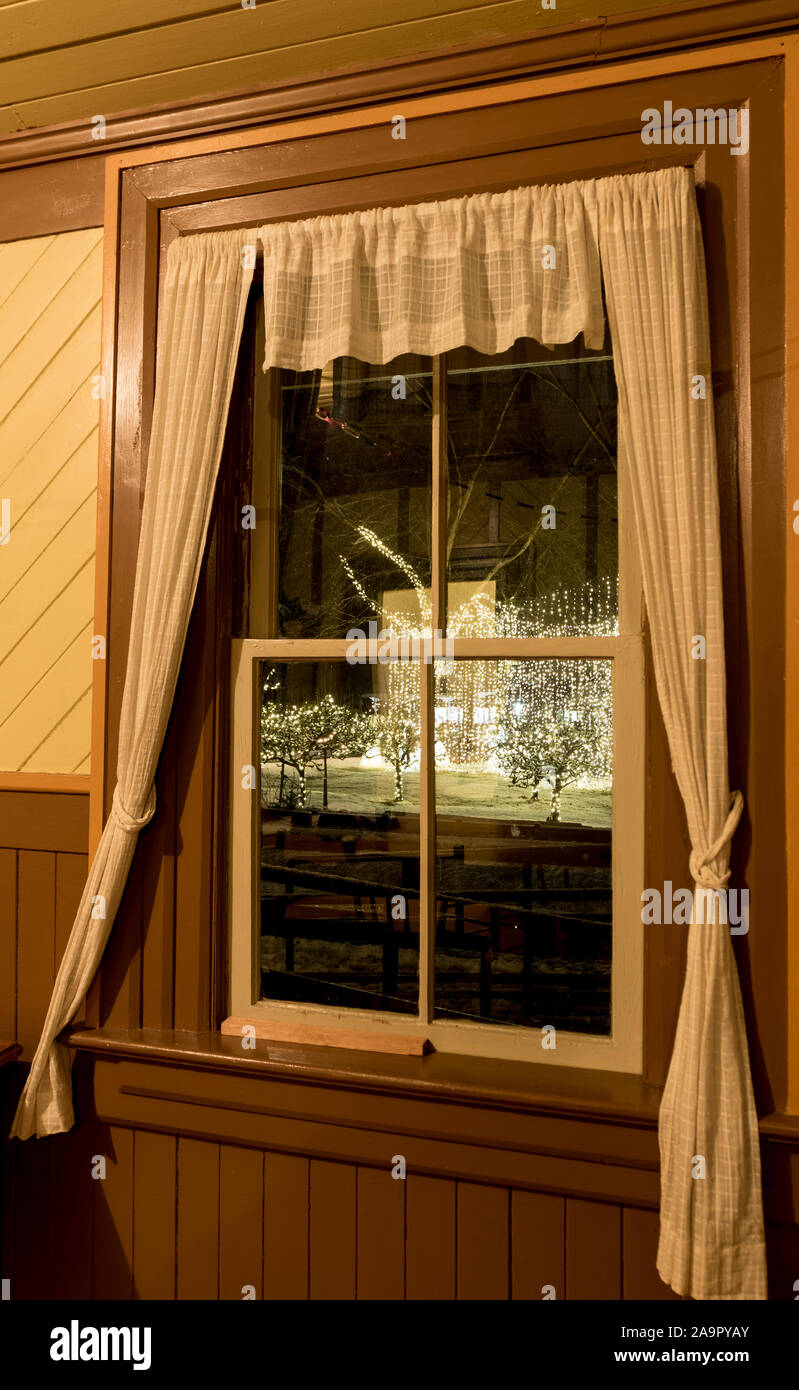 Outdoor string christmas lights visible from window while inside Stock