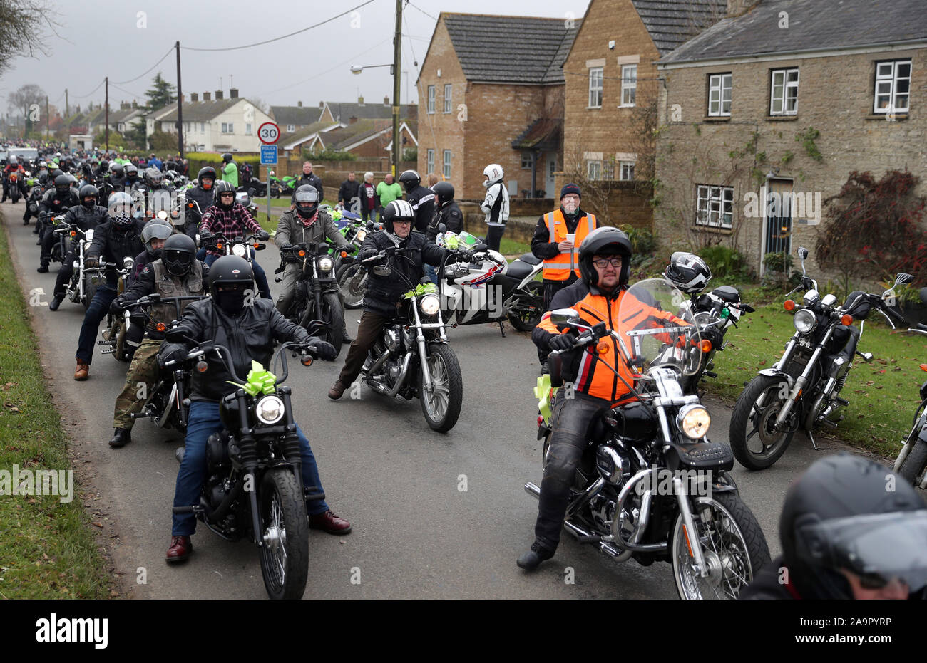 A motorbike convoy makes it's way through the village of Charlton as they follow Harry Dunn's last ride as a tribute to the teenager who died when his motorbike was involved in a head-on collision outside passes RAF Croughton, Northamptonshire, in August. Stock Photo