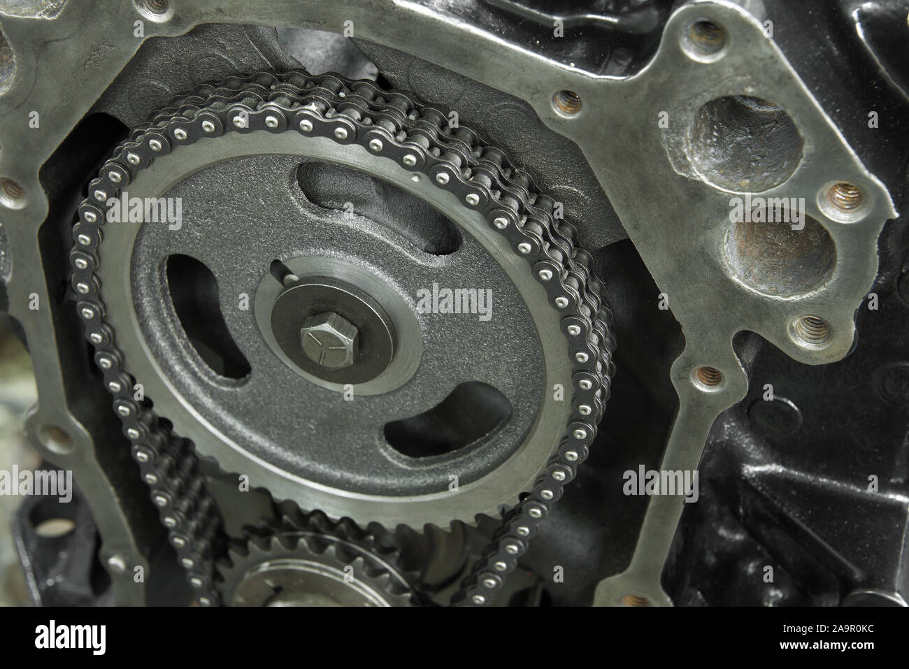 Camshaft drive gear with double-row chain close-up. Fragment of gas-reducing mechanism of classic American engine Stock Photo