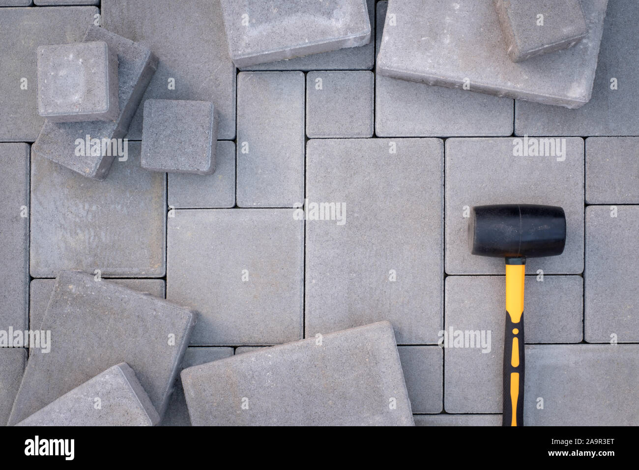 Paving stones paving background. Installing tools on foreground Stock Photo