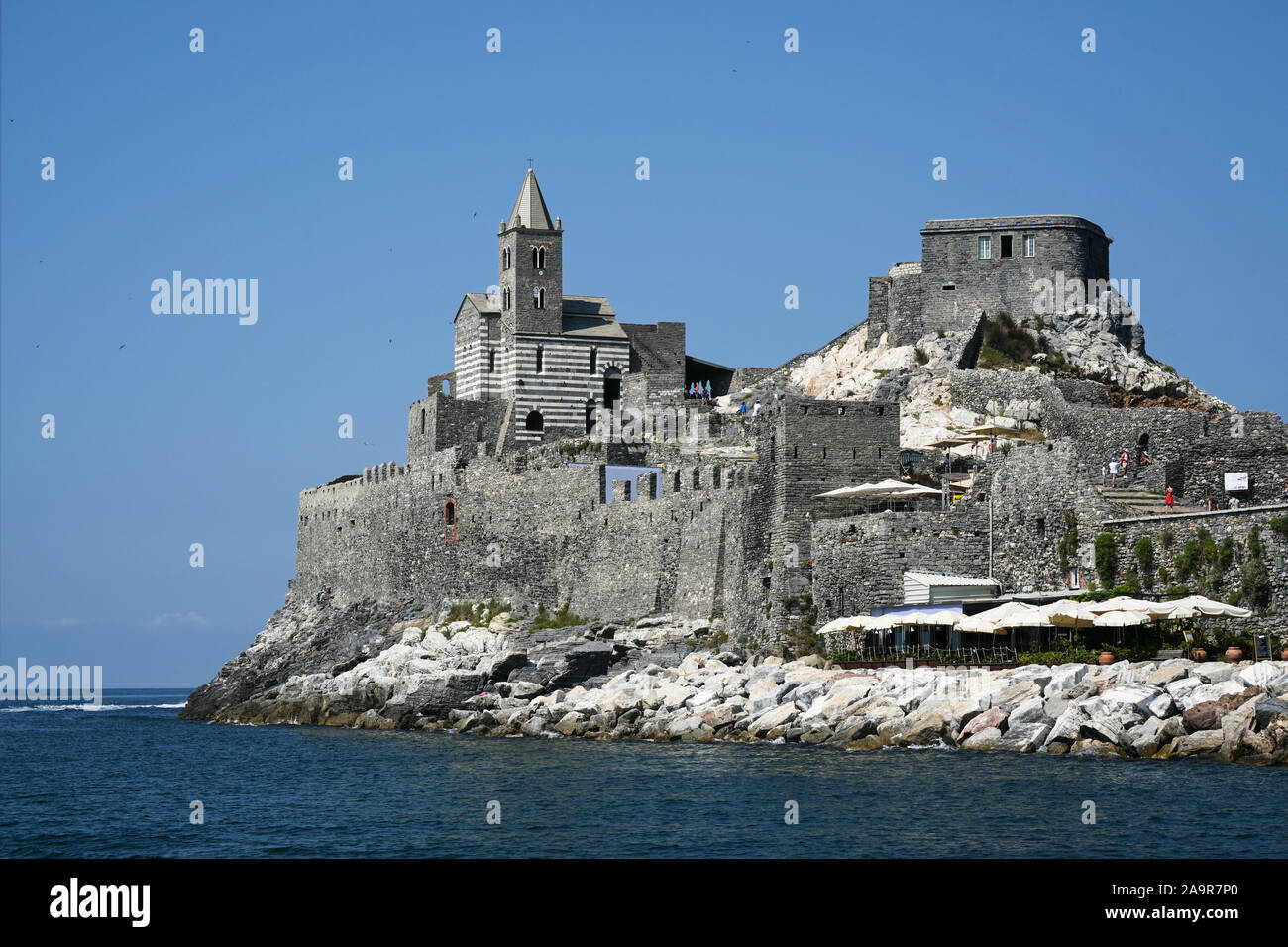 Saint Peter's Church (Chiesa di San Pietro) built on rough cliffs on the Gulf of Poets, blue sky with copy space, famous landmark in Portovenere Italy Stock Photo