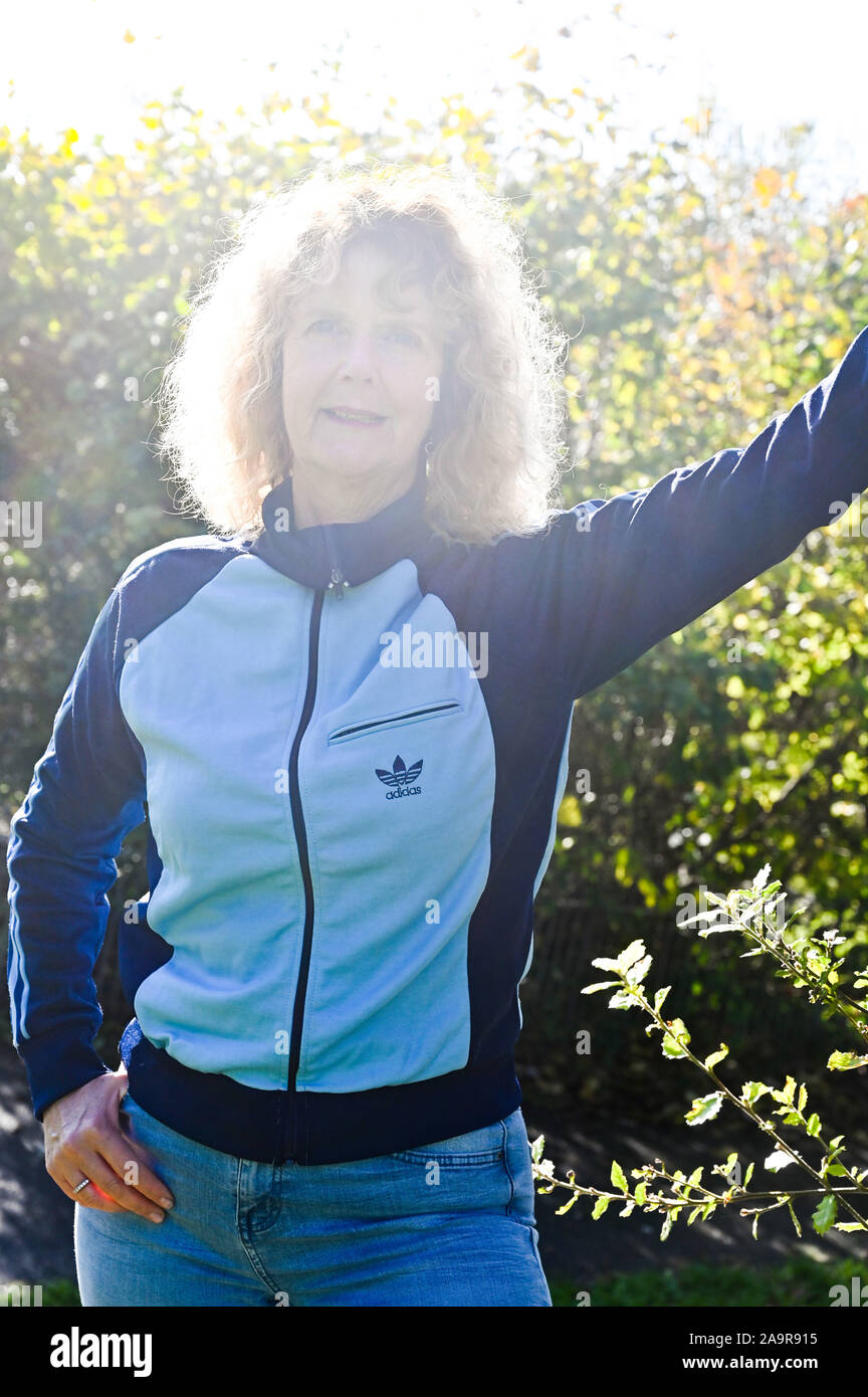 Mature middle aged woman wearing a retro Adidas tracksuit top made in the 1970s Stock Photo