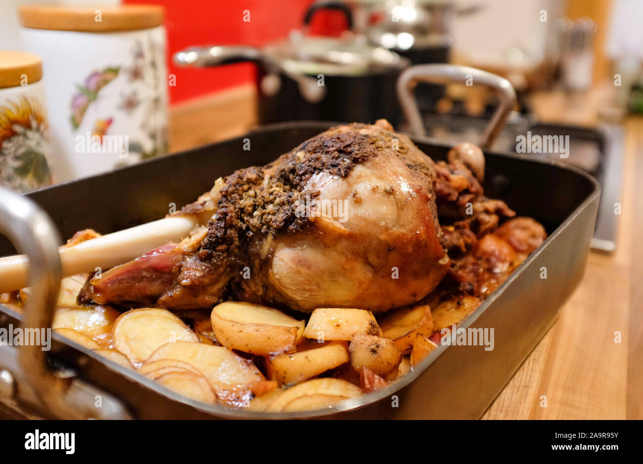 Home cooking slow roasting leg of lamb with spice rub and potatoes