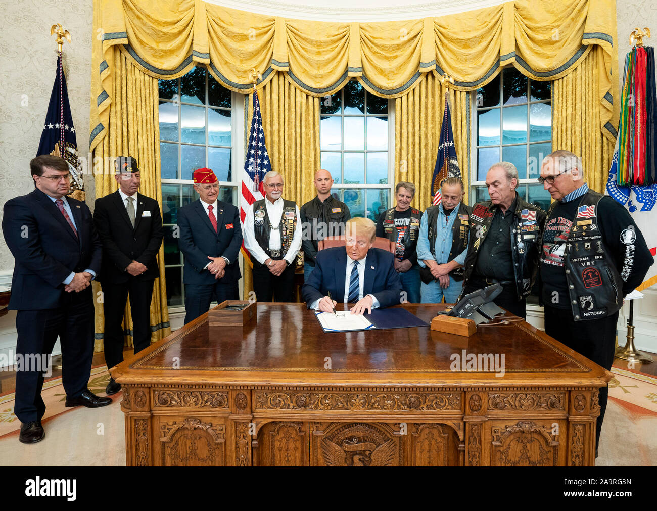 President Donald J. Trump , joined by Veterans Affairs Secretary Robert Wilke, left, and invited guests signs S. 693 the National POW/MIA Flag Act Thursday, Nov. 7, 2019, in the Oval Office of the White House. Stock Photo