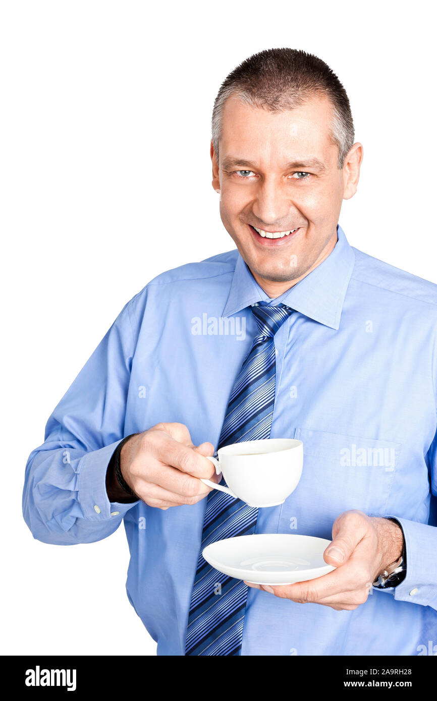 Ein lachender Geschaeftsmann vor weissem Hintergrund, der eine Tasse Kafee trinkt Stock Photo