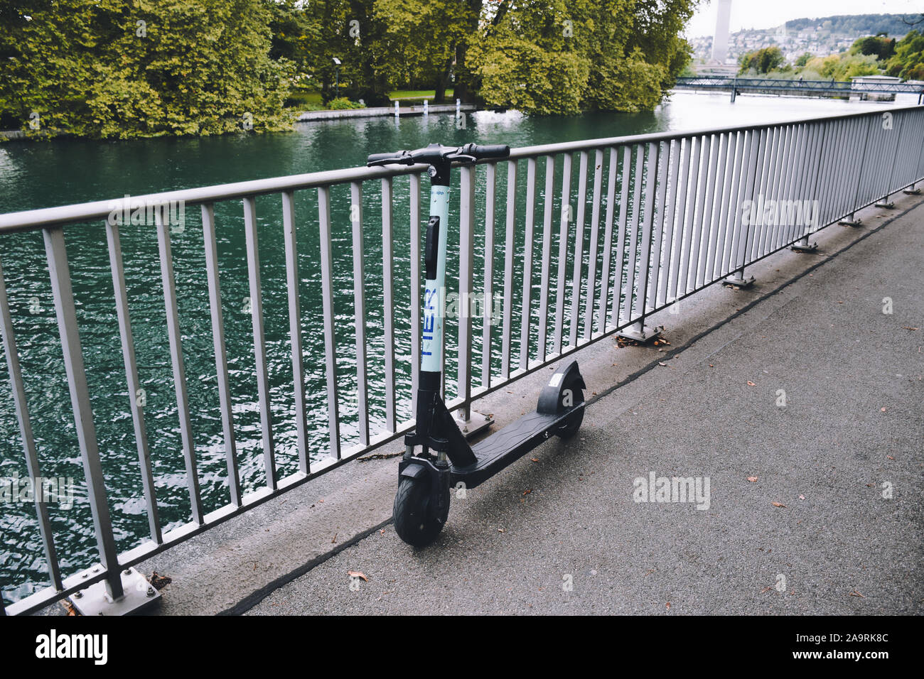 Zurich, Switzerland, 11.14.2019 Modern, electric TIER shared scooter leaning on the railings of