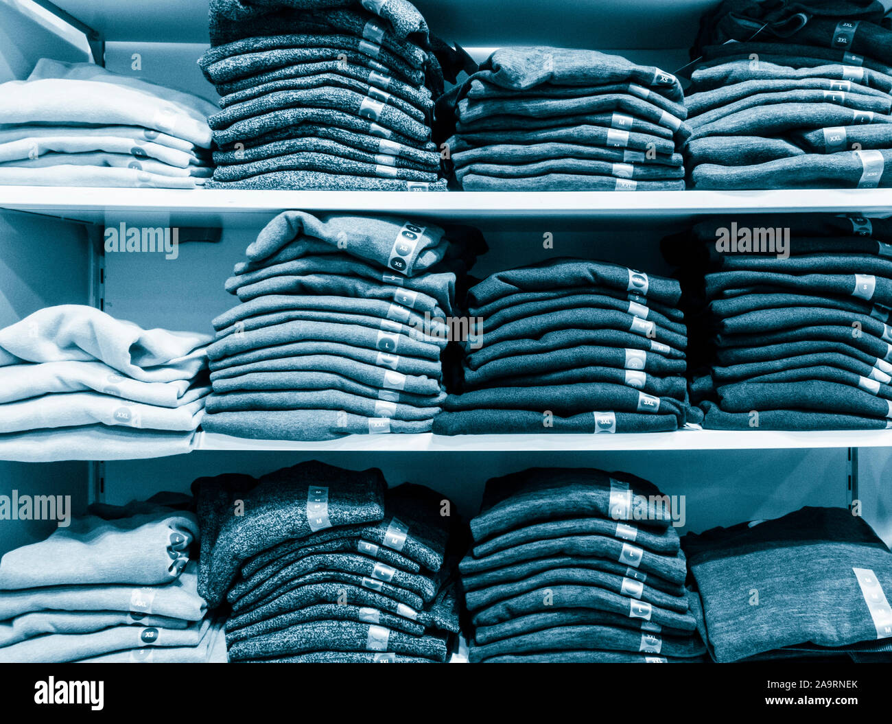 Folded jumpers, pullovers in clothing store. Stock Photo