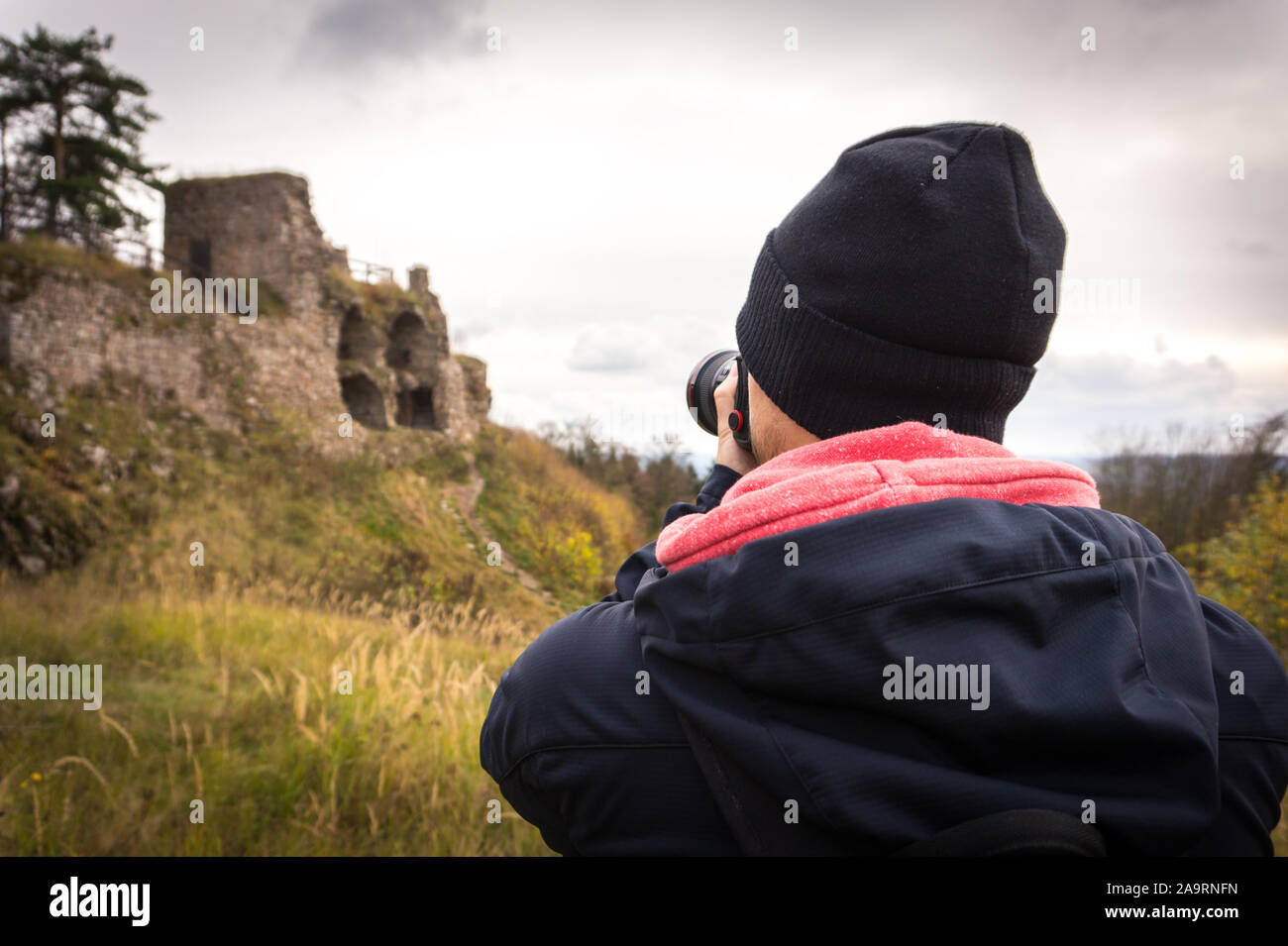 Young man tourist taking photos of castle ruin. Tourism. Stock Photo