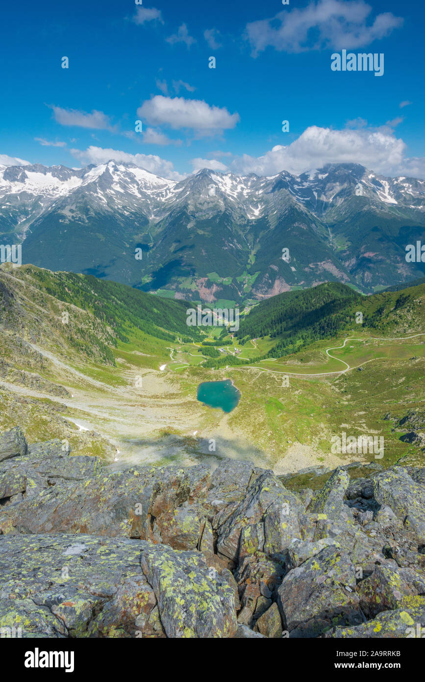 Amazing view of Klaus See in Ahrntal, with hiking trails crossing the mountain slopes and imposing snowcapped peaks on the other side of the valley. Stock Photo
