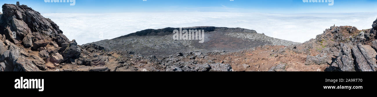 Large panoramic view of the pit crater at the top of the stratovolcano Mt Pico, Azores, taken from its pinnacle at 2351m above sea level. Stock Photo