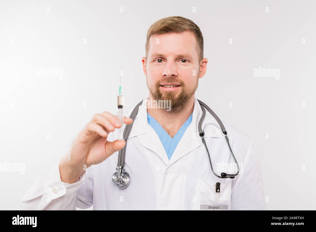 Successful Young Doctor With Stethoscope Holding Syringe In Front Of