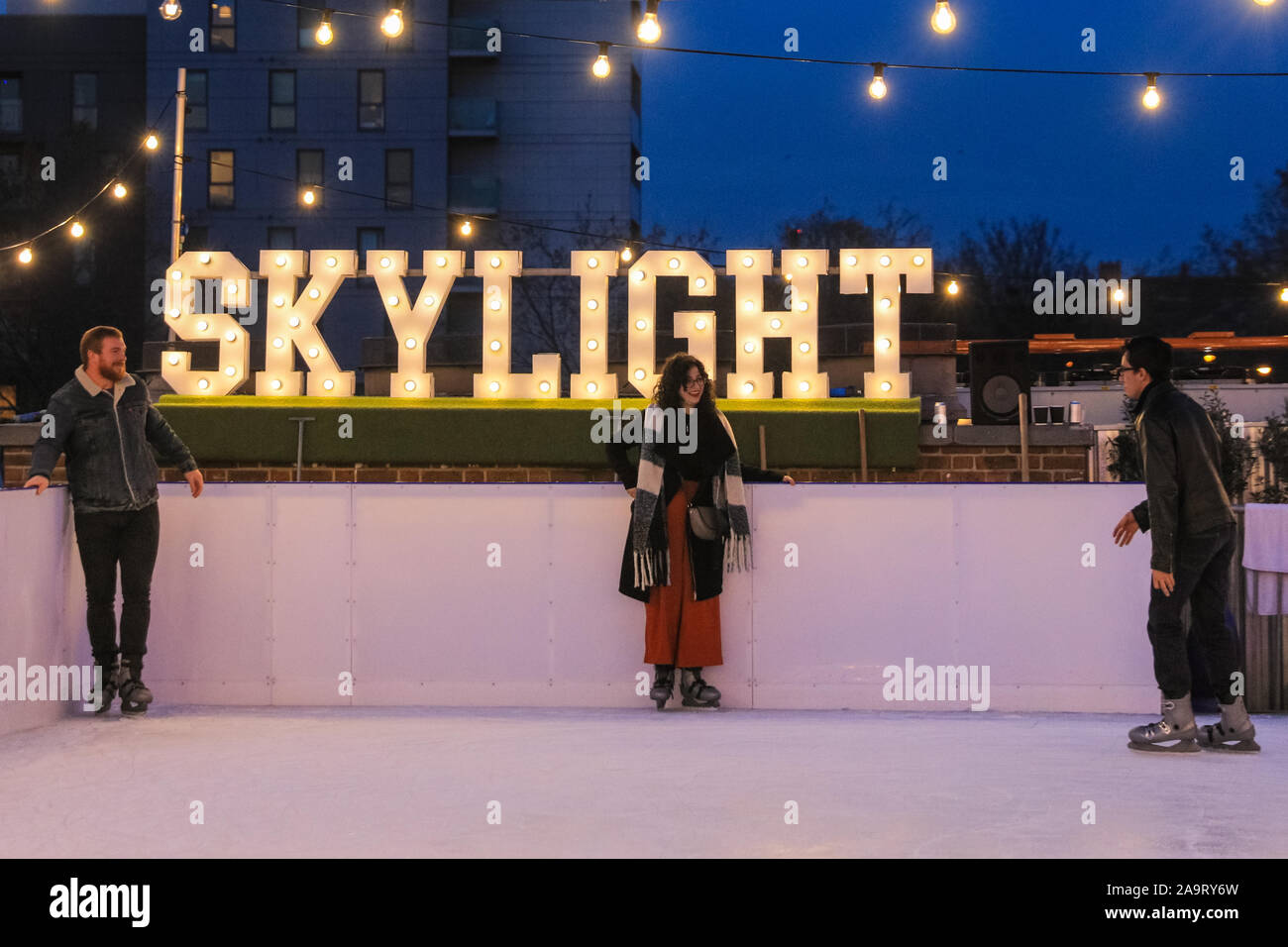 Tobacco Dock, London, UK, 17th November 2019. People enjoy spectacular views across to the City of London at London's trendy Skylight ice rink, a rooftop at the historic Tobacco Dock complex in Wapping, East London. Credit: Imageplotter/Alamy Live News Stock Photo