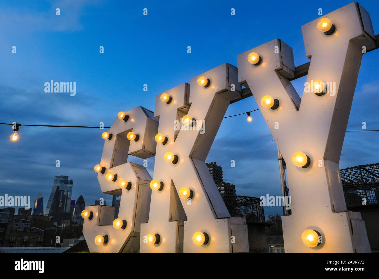 Tobacco Dock, London, UK, 17th November 2019. People enjoy spectacular  views across to the City of London at London's trendy Skylight ice rink, a  rooftop at the historic Tobacco Dock complex in
