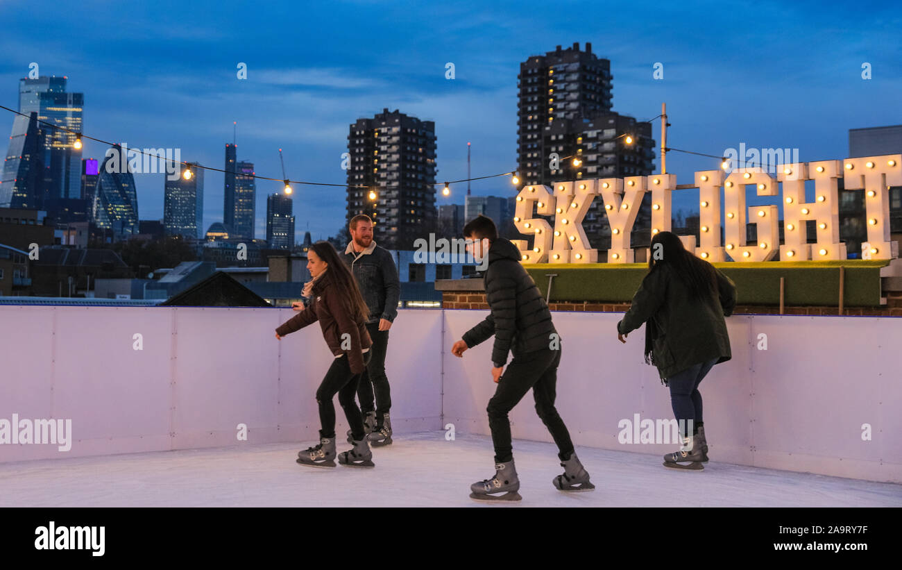 Tobacco Dock, London, UK, 17th November 2019. People enjoy spectacular views across to the City of London at London's trendy Skylight ice rink, a rooftop at the historic Tobacco Dock complex in Wapping, East London. Credit: Imageplotter/Alamy Live News Stock Photo