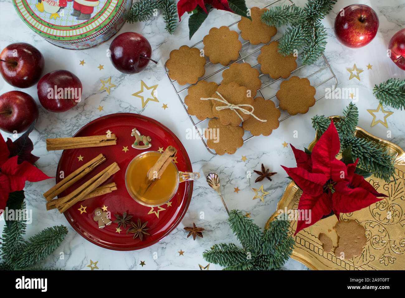 Food photography of a marble table top decorated with chic classy red and gold Chistmas cookies and spices Stock Photo