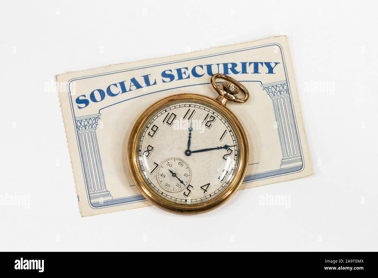 Old Social Security card with antique pocket watch and white background. Stock Photo