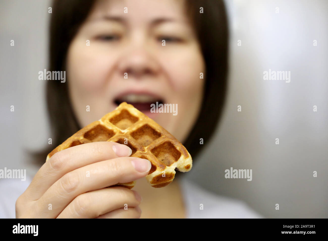 Diet and gluttony, woman eating belgian waffle, selective focus. Tasty breakfast close up, concept of temptation by delicious food, sweet tooth Stock Photo