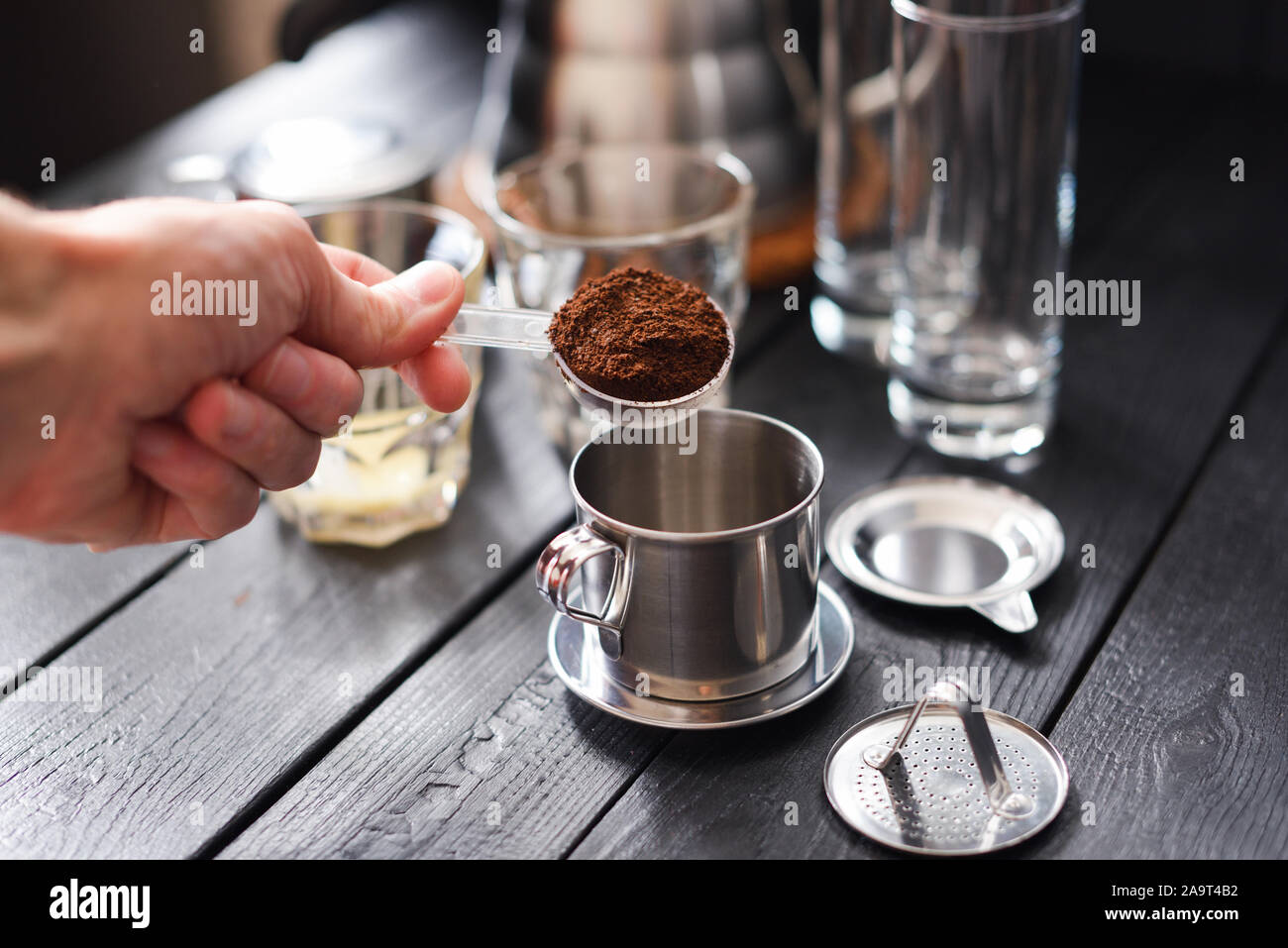 Preraring drip coffee Vietnamese style. Man hand pouring ground coffee