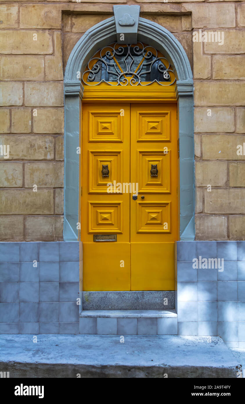 Wooden yellow door in a stone entry Stock Photo