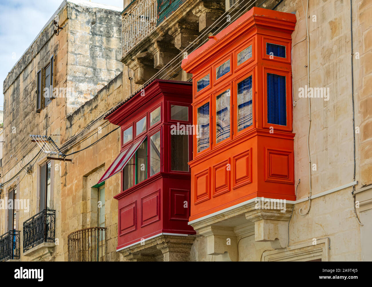 Two Maltese wooden balconies, red and orange Stock Photo