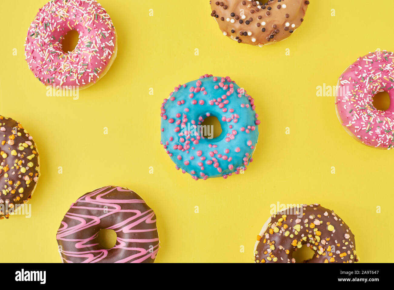 Color donut pattern on yellow background, top view flat lay Stock Photo ...