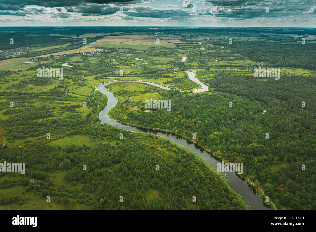 Aerial View Green Forest Woods And River Landscape In Summer Evening. Top View Of Beautiful European Nature From High Attitude In Summer Season. Drone Stock Photo