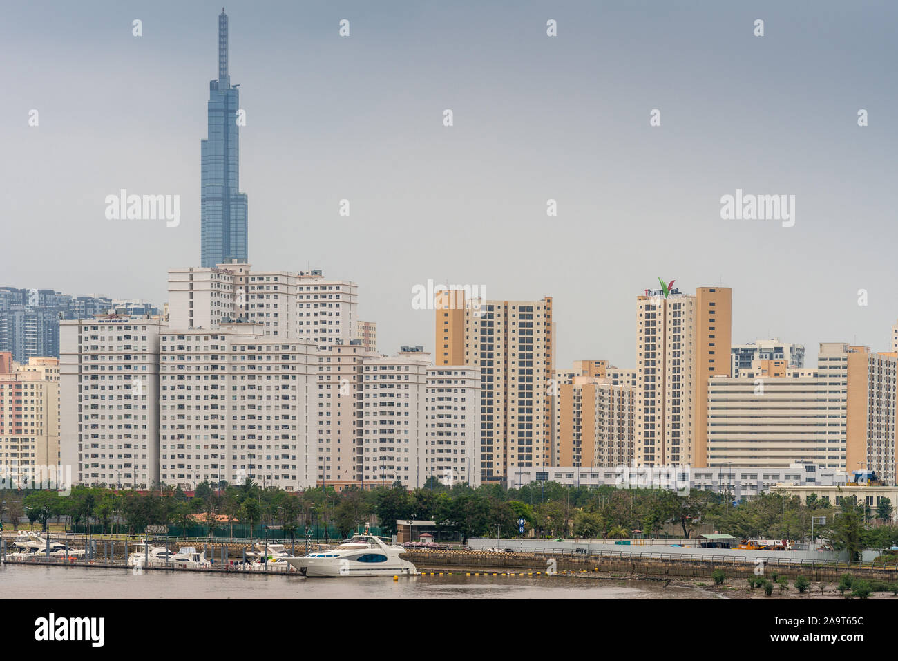 Ho Chi Minh City Vietnam - March 12, 2019: Song Sai Gon river. Royal Yacht Club with upscale motor boats in front of collection of apartment towers in Stock Photo