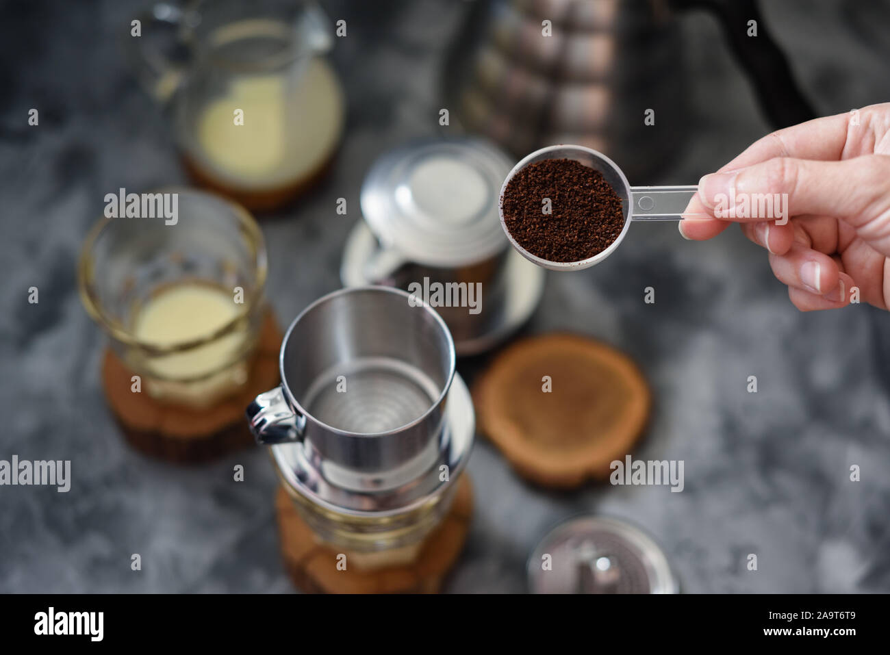 Making pour over Vietnamese milk coffee. Woman hand pouring coffee into
